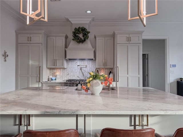 kitchen featuring crown molding, gray cabinetry, a large island, and tasteful backsplash