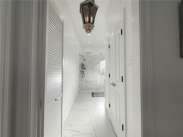 hall featuring marble finish floor and baseboards