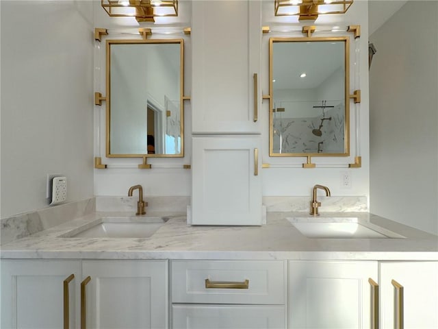 bathroom featuring walk in shower, double vanity, and a sink
