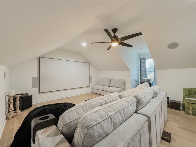 cinema with lofted ceiling, a ceiling fan, and light wood finished floors
