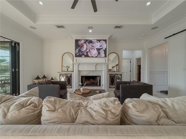 living room featuring visible vents, a fireplace, and a tray ceiling