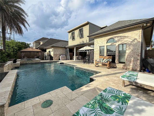 view of swimming pool featuring a fenced backyard, a pool with connected hot tub, and a patio area