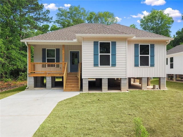 view of front facade with a porch, a front lawn, concrete driveway, and roof with shingles
