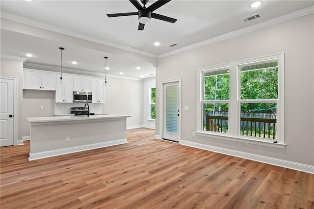 kitchen with visible vents, ceiling fan, light wood-style floors, and stainless steel microwave