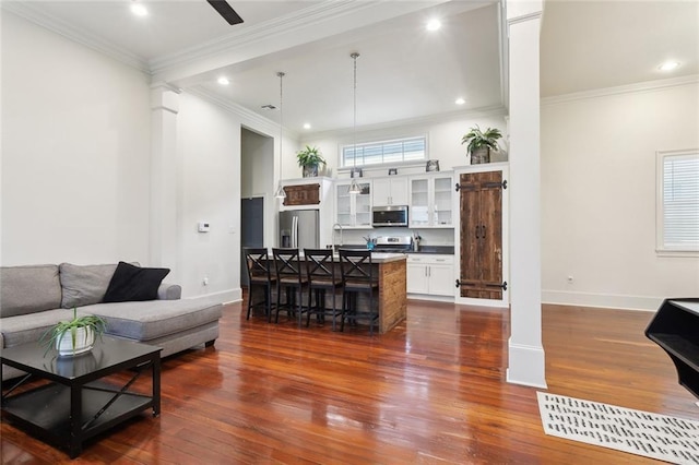 living room with baseboards, ornamental molding, and dark wood-style flooring