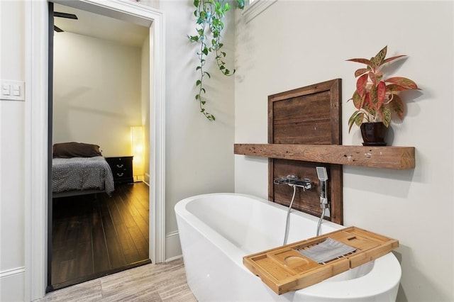 full bathroom with a freestanding tub and wood finished floors