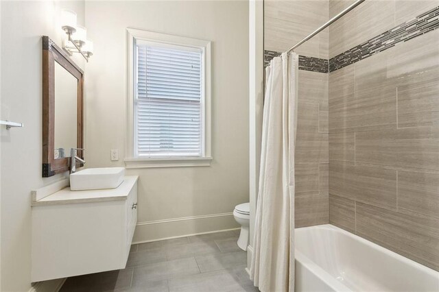 full bath with toilet, shower / bath combo, vanity, and baseboards