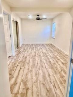 spare room featuring baseboards, a ceiling fan, and wood finished floors