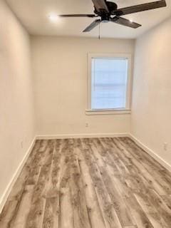 empty room with baseboards, a ceiling fan, and wood finished floors