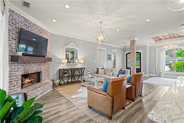 living area featuring a brick fireplace, recessed lighting, visible vents, and wood finished floors