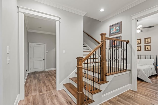 stairway featuring ornamental molding, a ceiling fan, wood finished floors, and baseboards