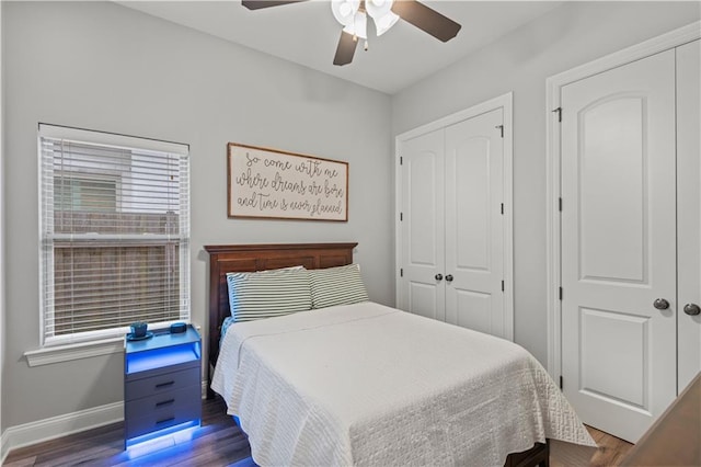 bedroom featuring baseboards, wood finished floors, a ceiling fan, and a closet