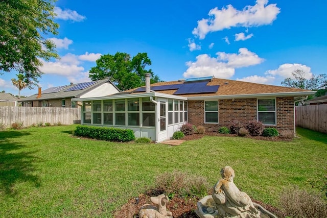 5 N Lafourche Ct, Kenner, LA 70065 - rear view of property with a yard, a sunroom, solar panels, and a fenced backyard
