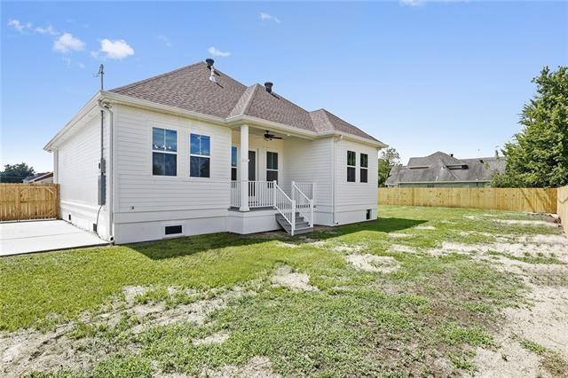 rear view of property featuring crawl space, a patio area, a fenced backyard, a lawn, and a ceiling fan