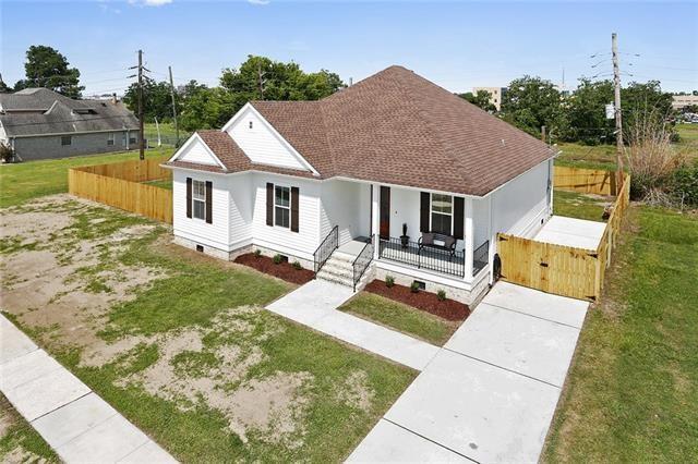 bungalow-style home featuring covered porch, a front yard, driveway, and crawl space
