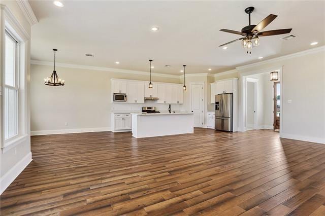 2832 Pirate Dr, Chalmette, LA 70043 - unfurnished living room featuring dark wood-style flooring, recessed lighting, ceiling fan, crown molding, and a chandelier