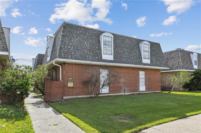2805 Kingman St, Metairie, LA 70006 - view of front facade featuring mansard roof, roof with shingles, brick siding, and a front lawn