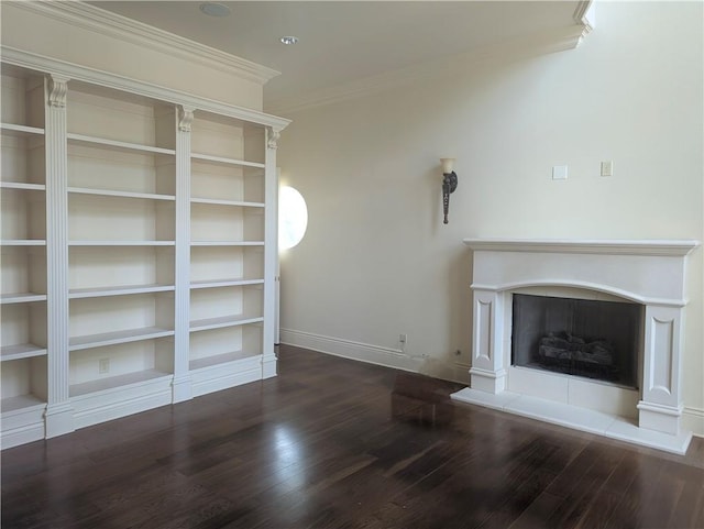 unfurnished living room featuring crown molding, a fireplace, wood finished floors, and baseboards