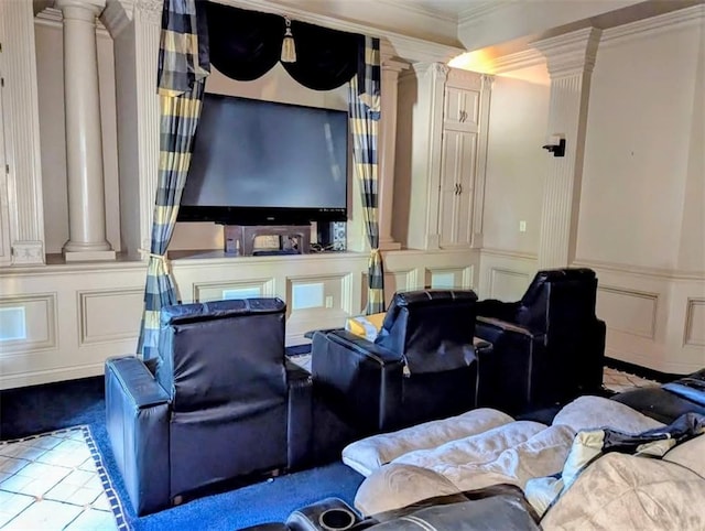 carpeted cinema featuring crown molding, a decorative wall, and ornate columns