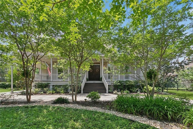 obstructed view of property featuring stairs, a front lawn, and covered porch