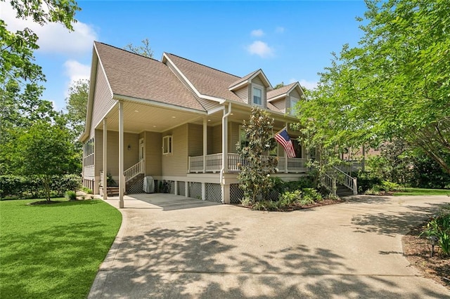 view of front of home with covered porch, a shingled roof, concrete driveway, and a front lawn