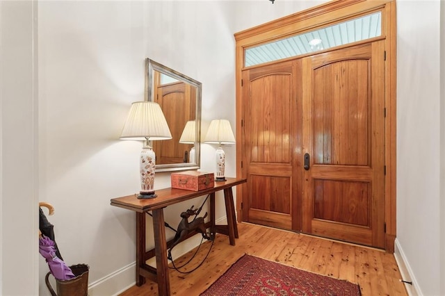 entrance foyer with baseboards and wood finished floors