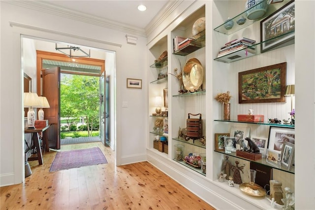 entryway featuring crown molding, baseboards, and wood finished floors
