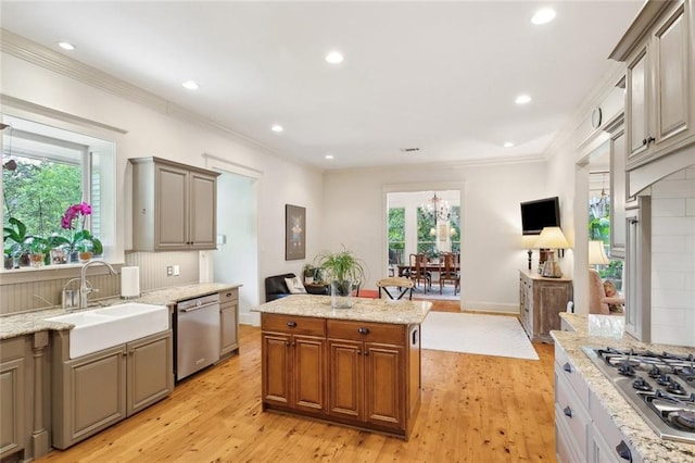kitchen featuring a sink, light wood finished floors, stainless steel appliances, recessed lighting, and ornamental molding