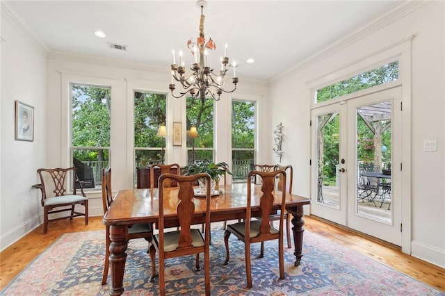 dining room featuring an inviting chandelier, french doors, baseboards, light wood-type flooring, and ornamental molding