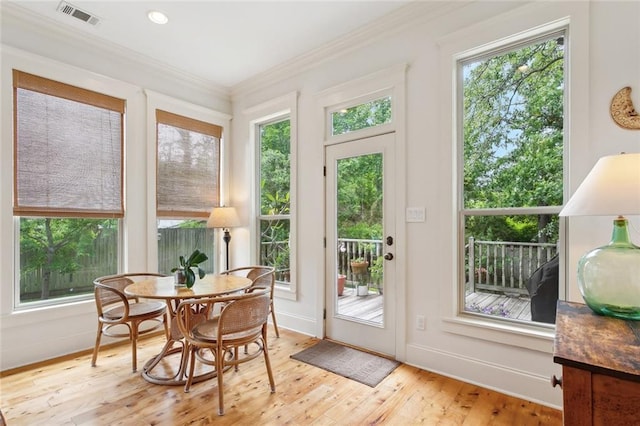 entryway featuring light wood-style floors, crown molding, and visible vents
