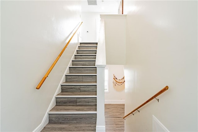 1379 Saint Anthony St, New Orleans, LA 70116 - stairway featuring visible vents, baseboards, and wood finished floors