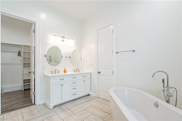 1379 Saint Anthony St, New Orleans, LA 70116 - bathroom with double vanity, a sink, a walk in closet, and a freestanding bath
