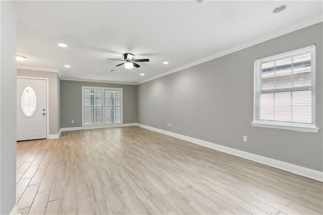 unfurnished living room featuring baseboards, ornamental molding, and ceiling fan