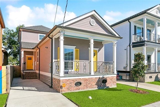 shotgun-style home featuring a porch, fence, and concrete driveway