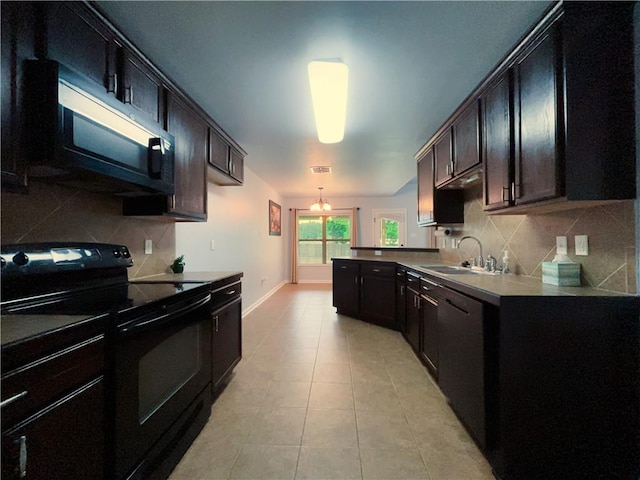 11601 Mary Lee Dr, Denham Springs, LA 70726 - kitchen featuring tasteful backsplash, a sink, baseboards, black appliances, and a peninsula