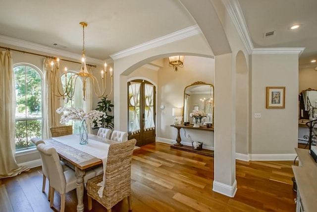 dining room with french doors, arched walkways, plenty of natural light, and a notable chandelier