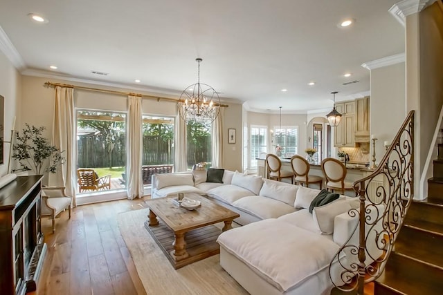 living area with crown molding, a notable chandelier, recessed lighting, and visible vents