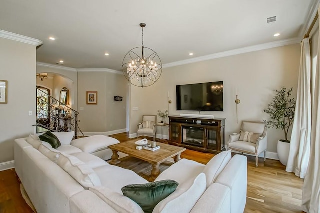 living room with visible vents, ornamental molding, baseboards, and wood finished floors