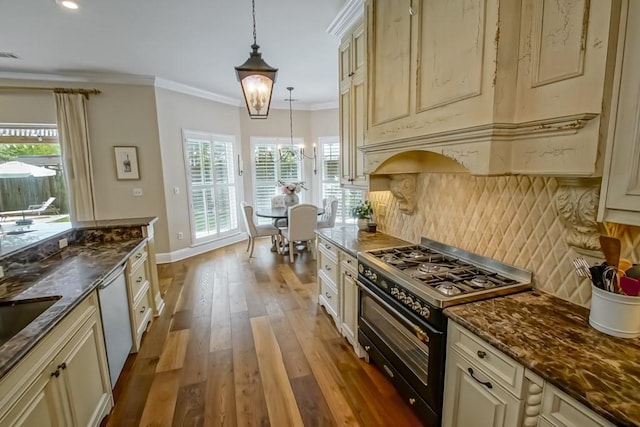 kitchen with light wood finished floors, dishwasher, range with two ovens, decorative backsplash, and cream cabinetry