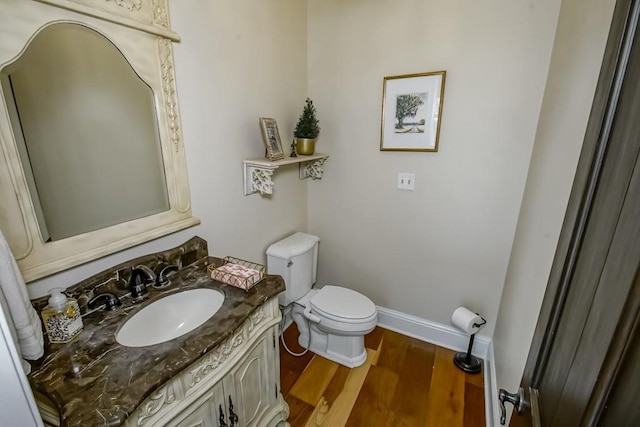 bathroom featuring vanity, baseboards, toilet, and wood finished floors