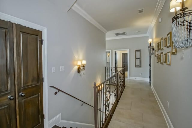 corridor with visible vents, baseboards, crown molding, and an upstairs landing