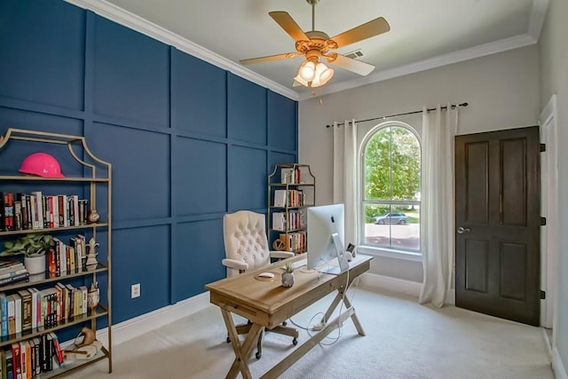 office featuring ceiling fan, visible vents, crown molding, light carpet, and a decorative wall
