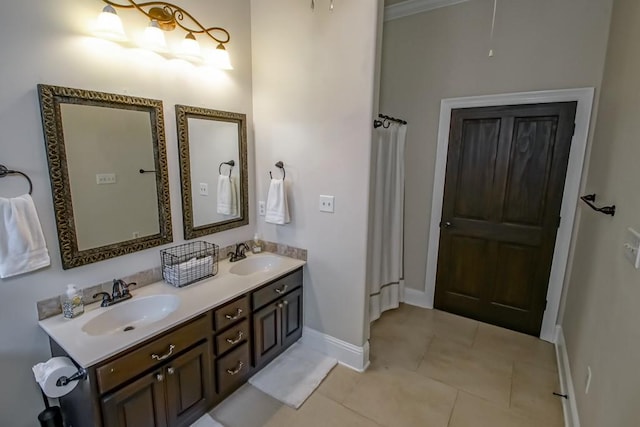 full bath featuring a sink, baseboards, tile patterned floors, and double vanity