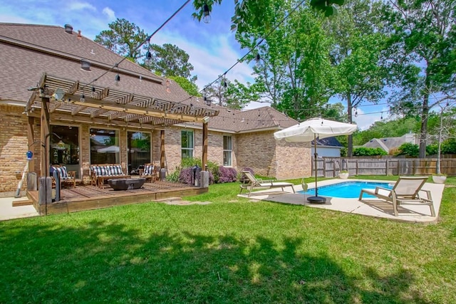 rear view of property featuring a pergola, a patio, a fenced backyard, brick siding, and a lawn