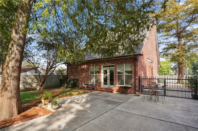 310 Orpheum Ave, Metairie, LA 70005 - back of property with french doors, roof with shingles, brick siding, fence, and a patio