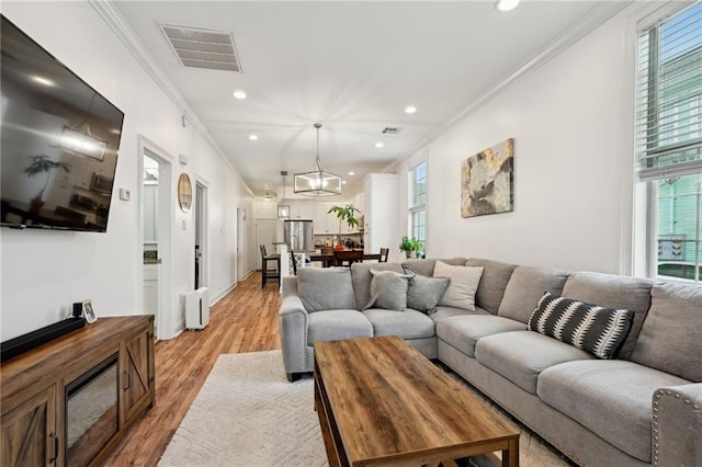 3301 Loyola Ave, New Orleans, LA 70115 - living room with visible vents, crown molding, and a healthy amount of sunlight