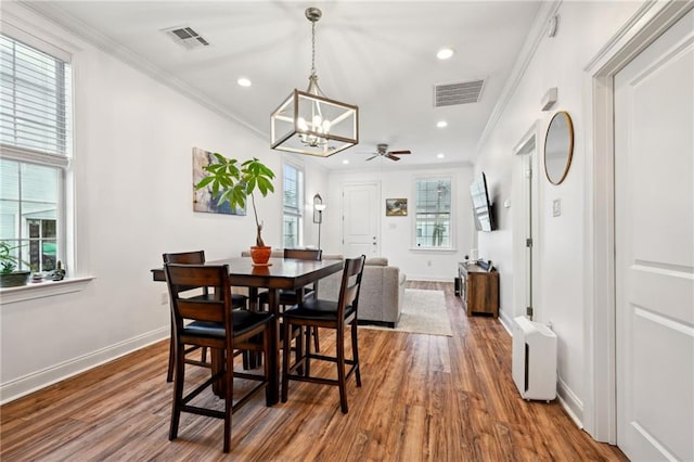 3301 Loyola Ave, New Orleans, LA 70115 - dining room featuring visible vents, ornamental molding, dark wood-type flooring, and recessed lighting