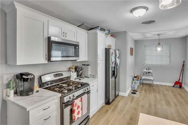 620 Maryland Ave, Metairie, LA 70003 - kitchen featuring stainless steel appliances, pendant lighting, white cabinets, baseboards, and light wood-style floors