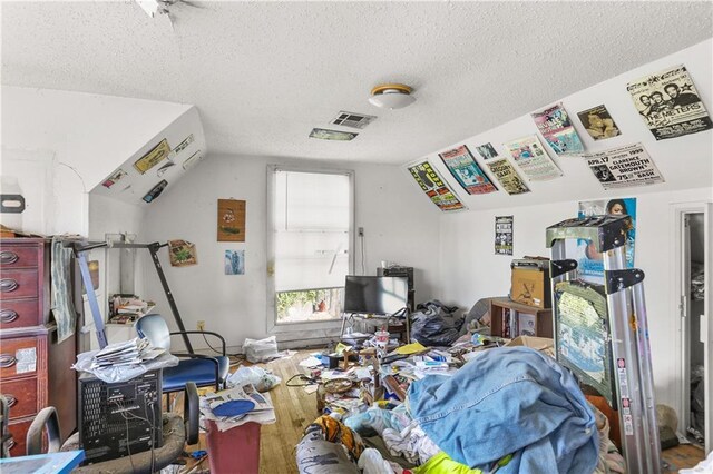 1717 Foucher St, New Orleans, LA 70115 - misc room featuring a textured ceiling, lofted ceiling, wood finished floors, and visible vents
