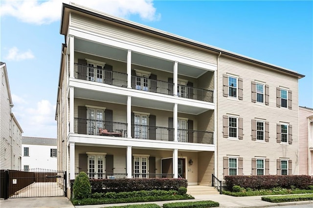 multi unit property featuring fence, a gate, and a balcony